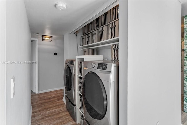 washroom with hardwood / wood-style flooring and washing machine and dryer