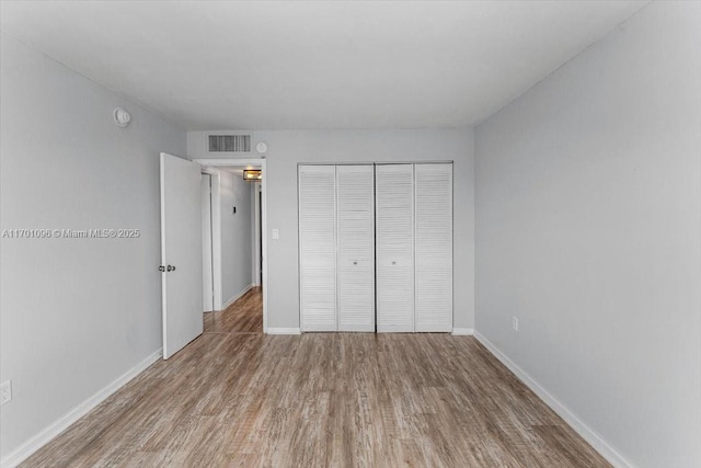 unfurnished bedroom with hardwood / wood-style floors and a closet