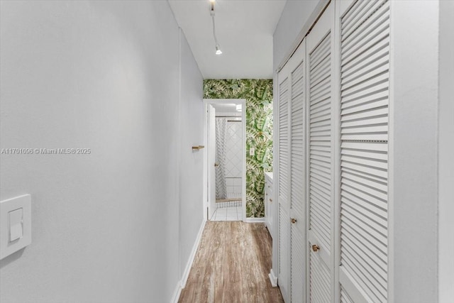 corridor with hardwood / wood-style flooring