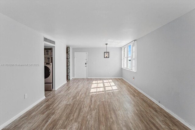 unfurnished room featuring wood-type flooring and washer / dryer