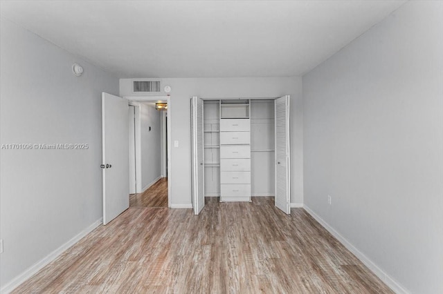 unfurnished bedroom featuring light hardwood / wood-style floors and a closet