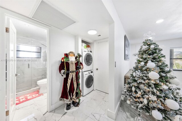 clothes washing area with stacked washer and dryer