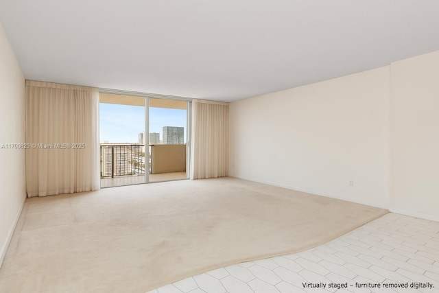 1865 S Ocean Dr Unit 16J, Hallandale Beach, FL 33009 - carpeted empty room with a wall of windows, baseboards, and tile patterned floors