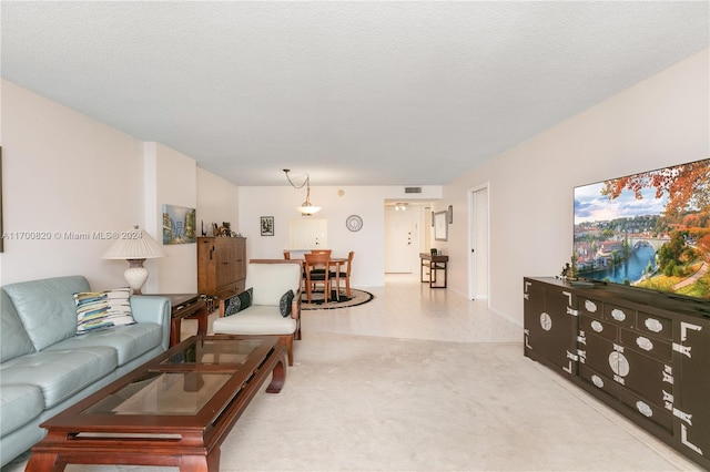 living room featuring a textured ceiling and light colored carpet