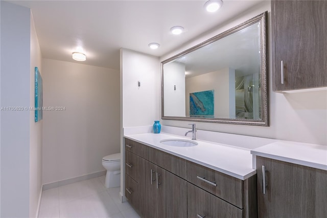 bathroom with tile patterned flooring, vanity, and toilet