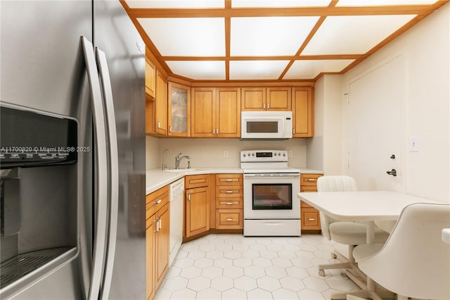 1865 S Ocean Dr Unit 16J, Hallandale Beach, FL 33009 - kitchen with white appliances, a sink, light countertops, glass insert cabinets, and brown cabinets