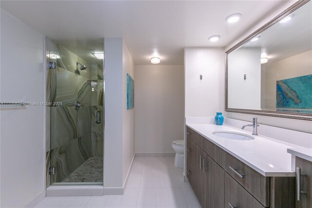 bathroom featuring tile patterned flooring, vanity, toilet, and an enclosed shower