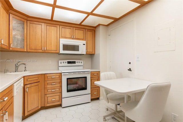 kitchen featuring white appliances, electric panel, and sink