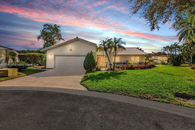 ranch-style house featuring a lawn and a garage