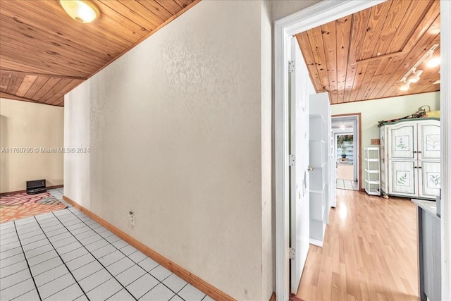 corridor with light hardwood / wood-style floors, crown molding, lofted ceiling, and wood ceiling