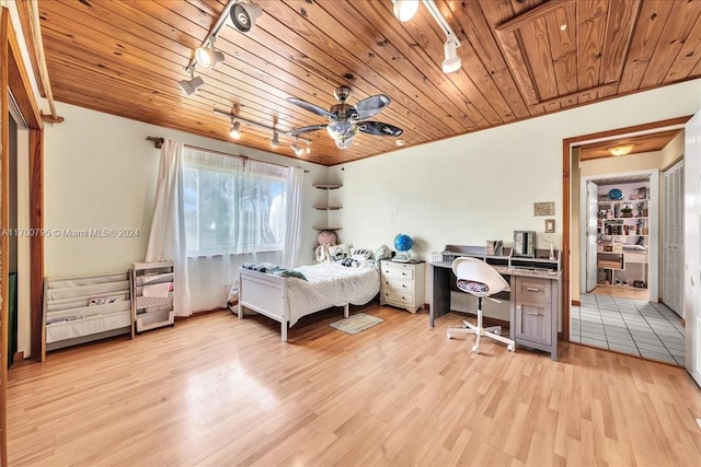 bedroom with ceiling fan, wood ceiling, track lighting, and light wood-type flooring