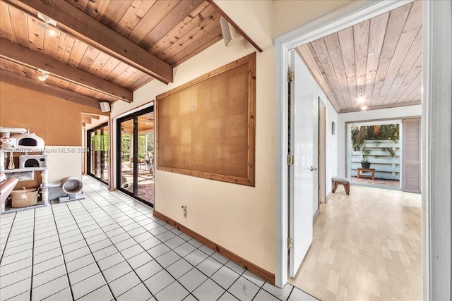 hallway with french doors, vaulted ceiling with beams, light hardwood / wood-style flooring, and wooden ceiling