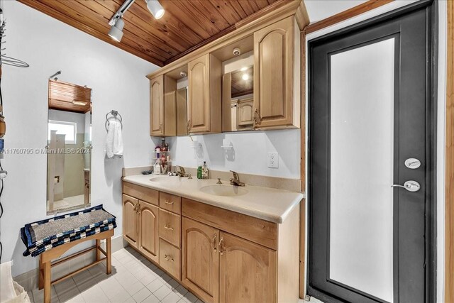 kitchen featuring light tile patterned floors, track lighting, wooden ceiling, and sink