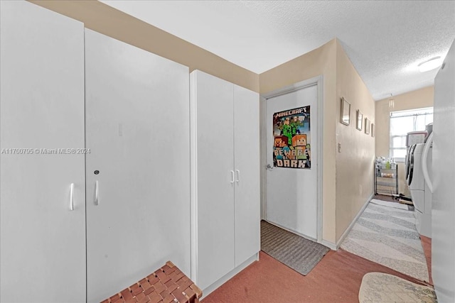 hall featuring a textured ceiling and light carpet