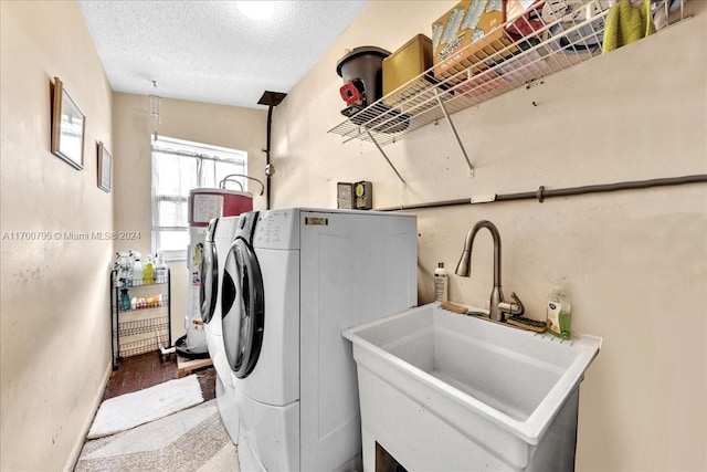 laundry room with washer and clothes dryer, a textured ceiling, and sink