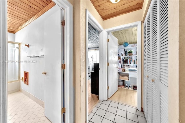 hallway featuring light hardwood / wood-style flooring, wooden ceiling, and ornamental molding