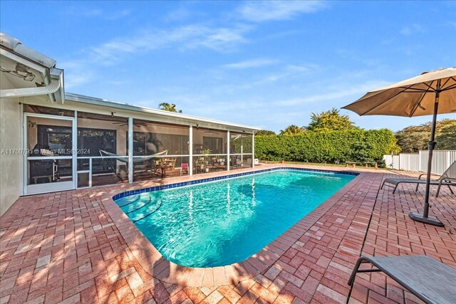 view of pool featuring a sunroom and a patio