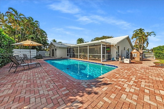 view of swimming pool with a patio area and a sunroom