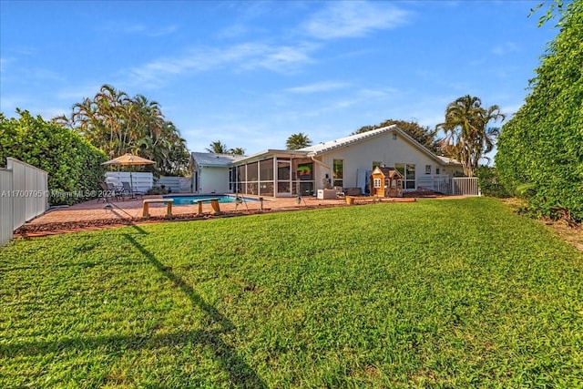 view of yard with a sunroom, a fenced in pool, and a patio