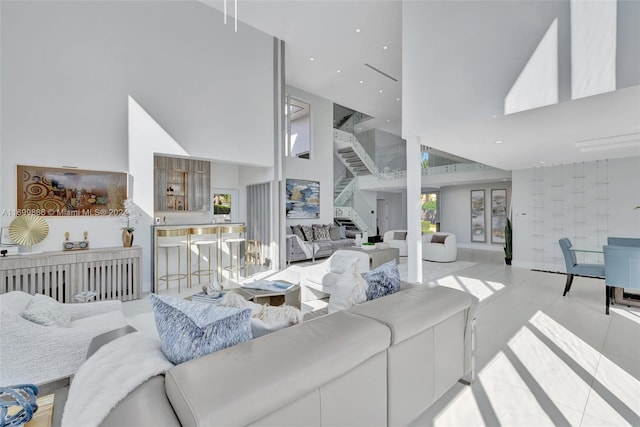 living room with light tile patterned flooring and a towering ceiling