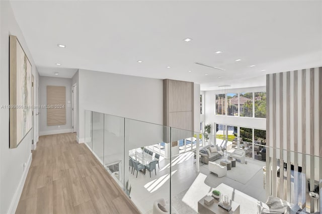 corridor with a towering ceiling and light hardwood / wood-style flooring