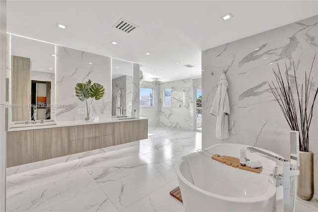 bathroom with vanity, a bathing tub, and tile walls