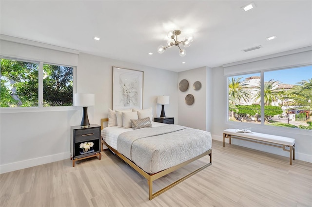 bedroom with a chandelier and light hardwood / wood-style flooring