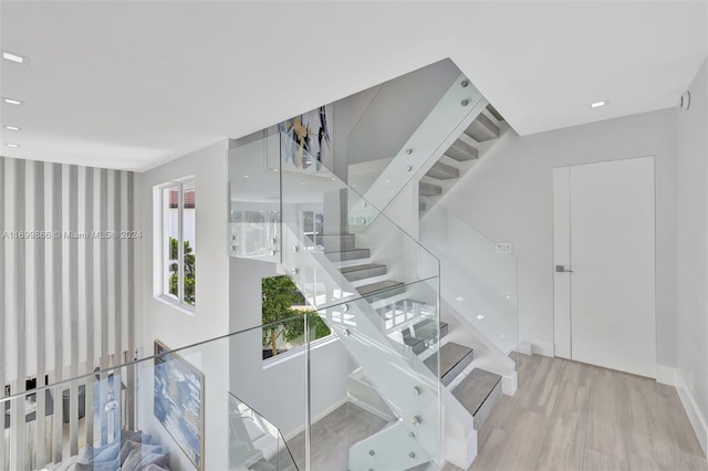 staircase with hardwood / wood-style floors