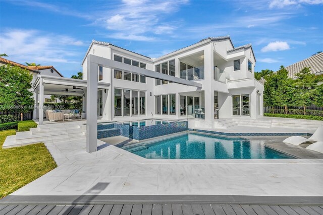 rear view of house with a patio, outdoor lounge area, ceiling fan, and a lawn