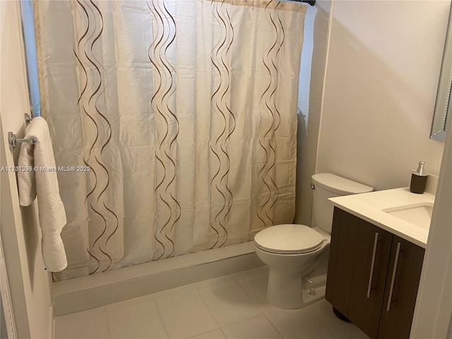 bathroom featuring a shower with shower curtain, vanity, toilet, and tile patterned floors