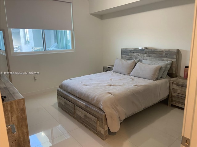 bedroom with baseboards and light tile patterned floors