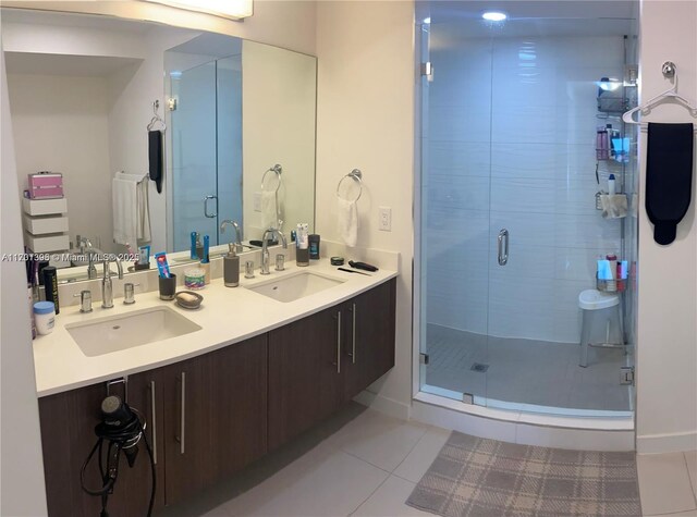 bathroom featuring tile patterned flooring, vanity, and a shower with door