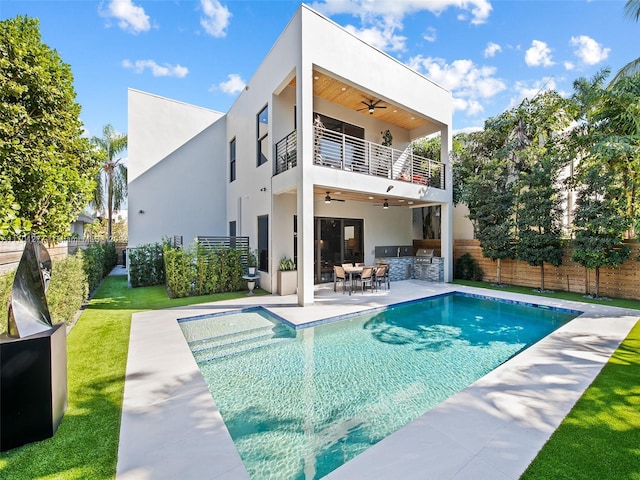 rear view of house featuring a fenced in pool, ceiling fan, a balcony, exterior kitchen, and a patio