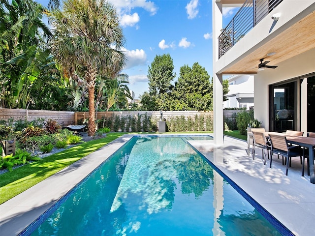 view of pool featuring outdoor dining area, a fenced backyard, a ceiling fan, a fenced in pool, and a patio area