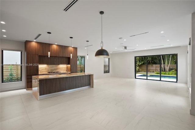 kitchen with recessed lighting, modern cabinets, backsplash, light countertops, and open floor plan