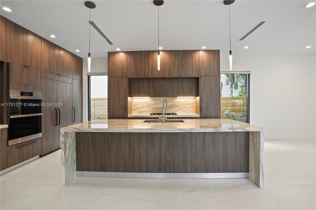 kitchen featuring a sink, a large island with sink, recessed lighting, and modern cabinets