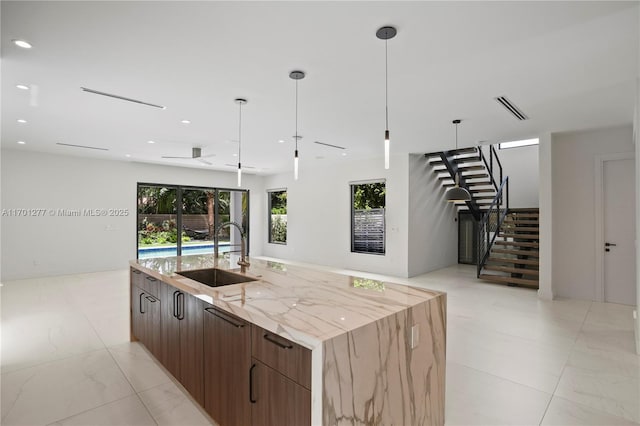 kitchen with visible vents, open floor plan, modern cabinets, and a sink