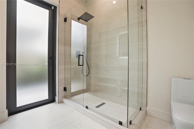 bathroom featuring a stall shower, toilet, and marble finish floor