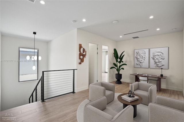 living area with baseboards, light wood-style flooring, recessed lighting, and a notable chandelier