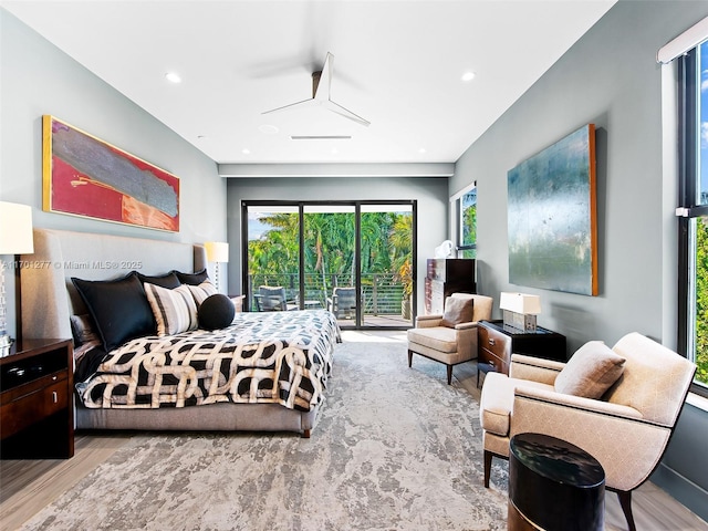 bedroom with access to outside, recessed lighting, and wood finished floors