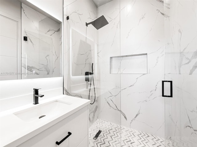 full bath featuring vanity and a marble finish shower