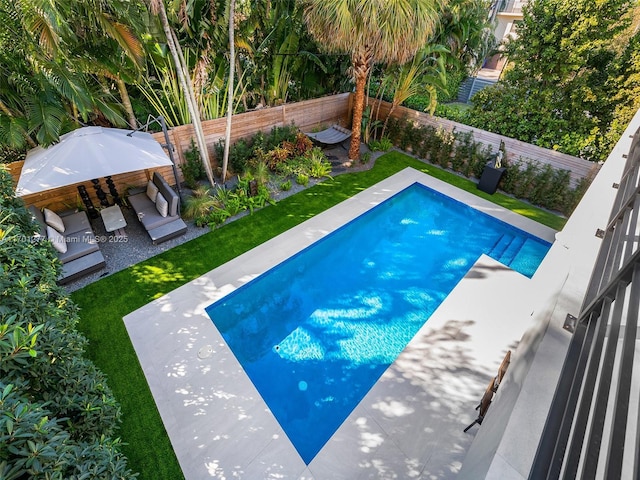 view of swimming pool featuring a yard, a patio, a fenced in pool, and a fenced backyard