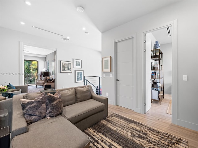 living room featuring light wood-type flooring, baseboards, and recessed lighting