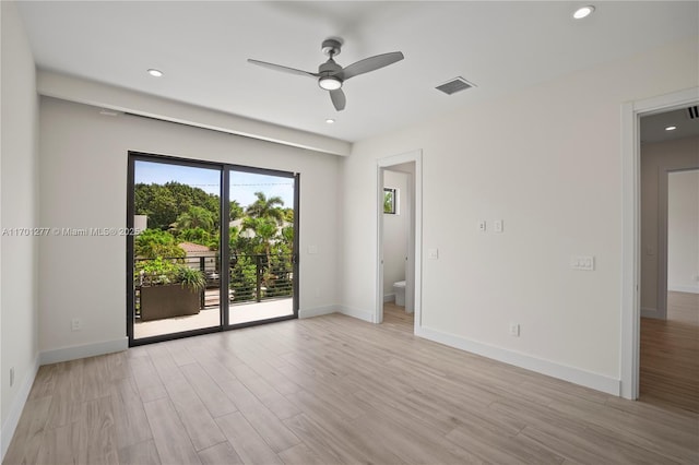 spare room featuring ceiling fan, light wood-type flooring, visible vents, and baseboards