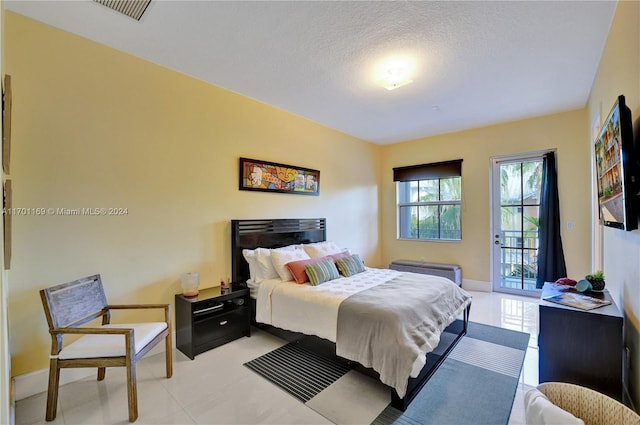 bedroom featuring access to outside and a textured ceiling