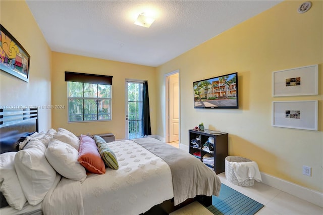 bedroom featuring light tile patterned floors and a textured ceiling