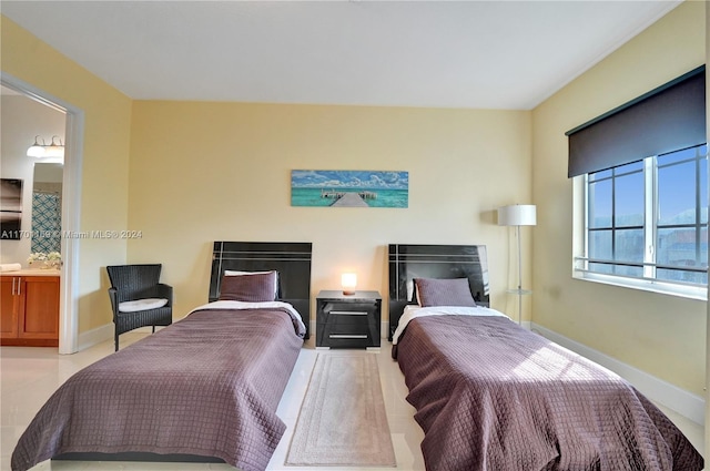 bedroom featuring light tile patterned floors and connected bathroom