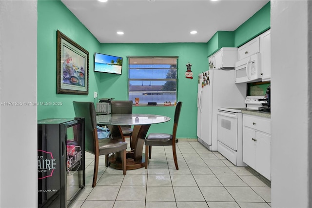 kitchen featuring white cabinetry, white appliances, and light tile patterned floors