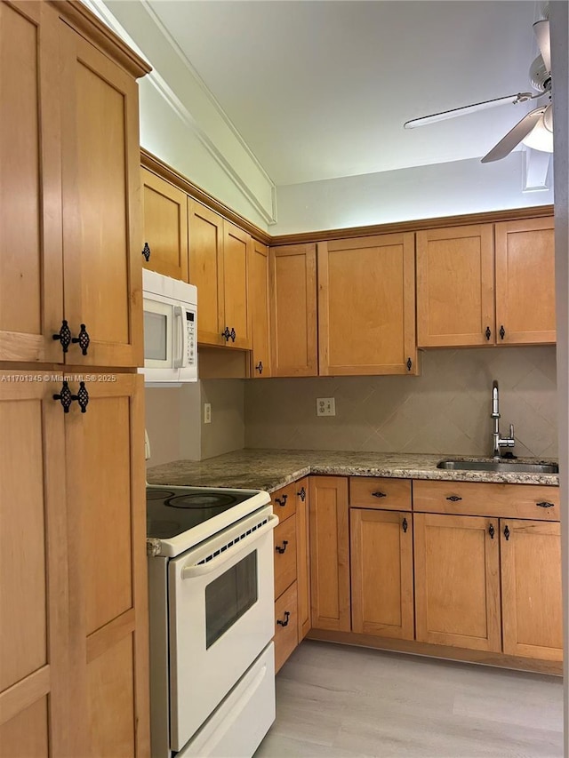 kitchen featuring sink, light stone counters, white appliances, ceiling fan, and light hardwood / wood-style floors