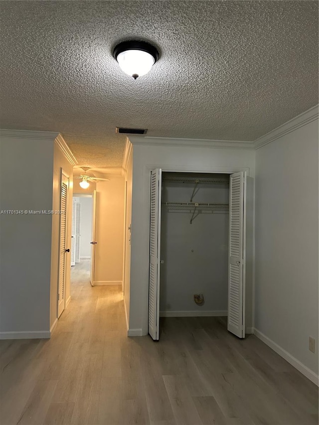 corridor with crown molding, wood-type flooring, and a textured ceiling